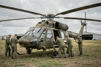 Hélicoptère Gazelle de l'Armée de Terre française en inspection pré-vol sur un terrain militaire avec équipage au sol