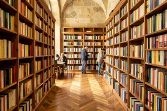 Intérieur d'une librairie indépendante dans le Rhône avec des étagères remplies de livres et des clients qui parcourent les rayons