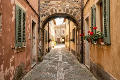 Ruelle en pierre d'une petite ville italienne avec arcades et volets colorés typiques